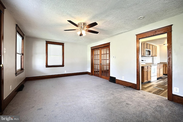 unfurnished room with a textured ceiling, light colored carpet, and ceiling fan