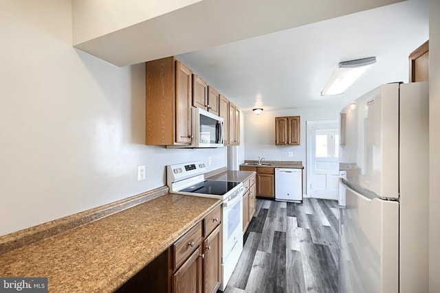 kitchen with dark hardwood / wood-style floors, white appliances, and sink