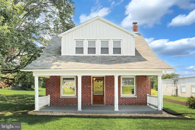 view of front facade featuring a front yard and covered porch