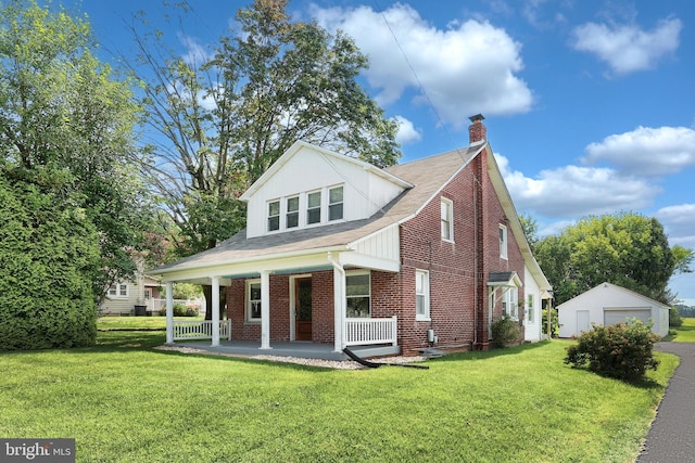 view of front facade with a front lawn, covered porch, a garage, and an outdoor structure