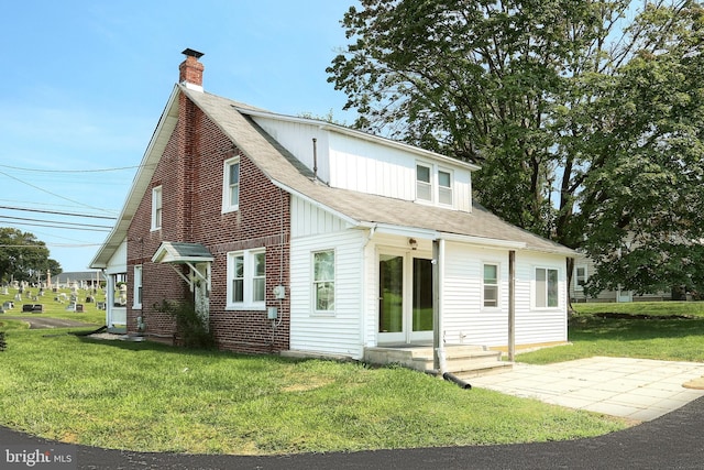 rear view of property featuring a yard