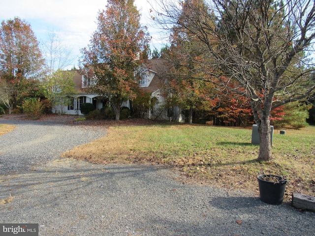 view of property hidden behind natural elements featuring a front lawn