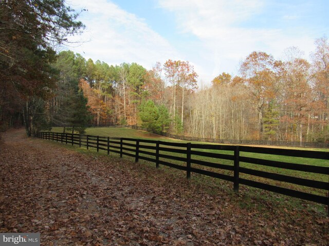 view of gate with a yard and a rural view