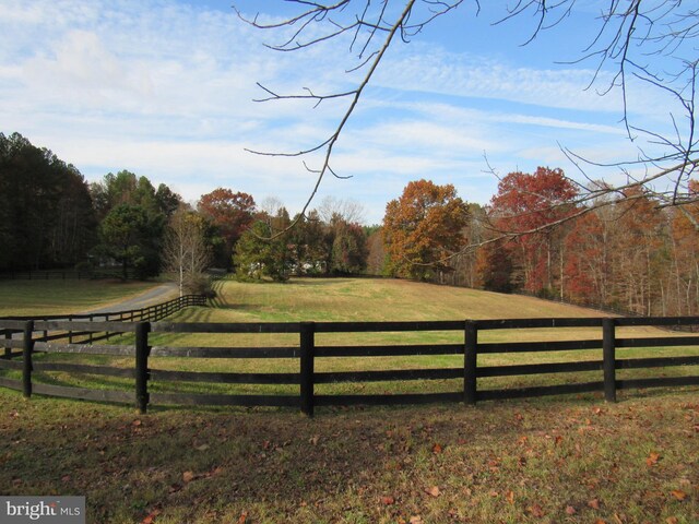 view of gate with a yard and a rural view