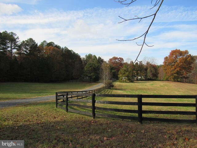 view of gate with a rural view and a lawn