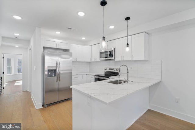 kitchen featuring stainless steel appliances, white cabinetry, sink, light wood-type flooring, and decorative backsplash