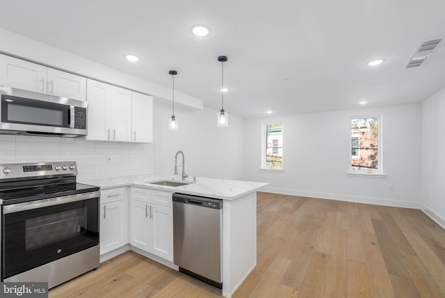 kitchen featuring white cabinetry, stainless steel appliances, sink, and light hardwood / wood-style flooring