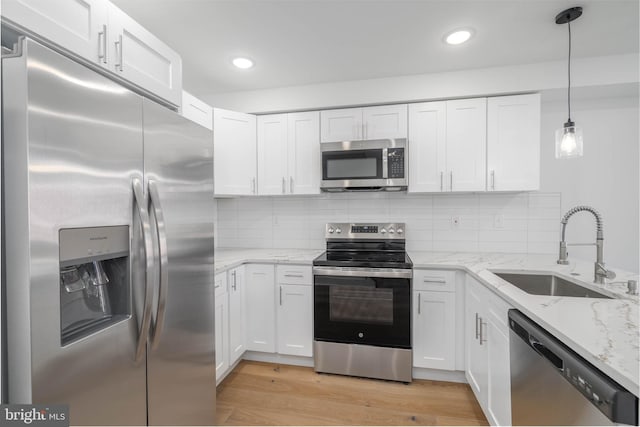 kitchen with stainless steel appliances, white cabinetry, and sink