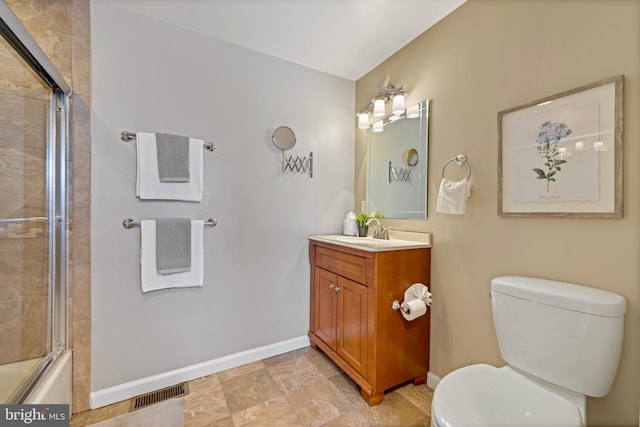 full bathroom featuring vanity, bath / shower combo with glass door, and toilet