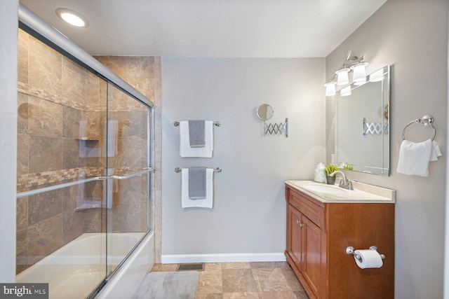 bathroom with vanity and bath / shower combo with glass door