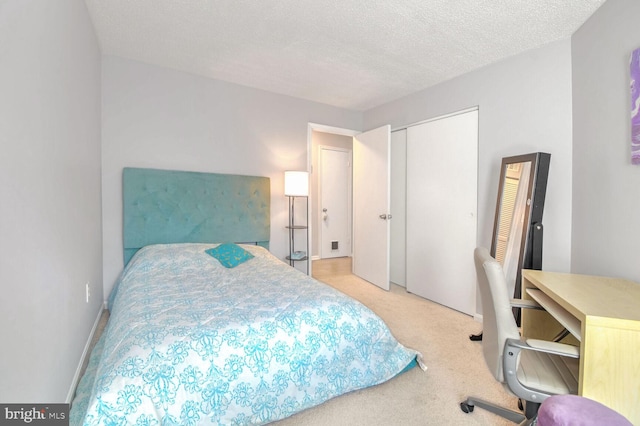 bedroom featuring light carpet, a textured ceiling, and a closet