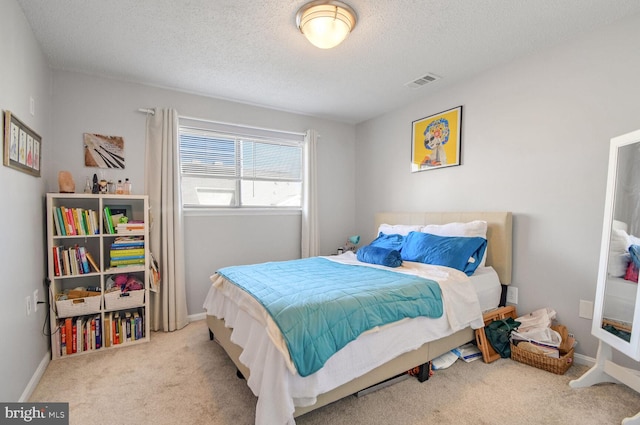 bedroom featuring a textured ceiling and light carpet