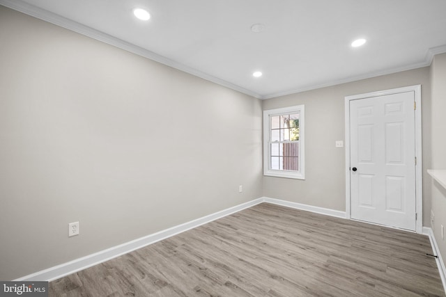 spare room featuring hardwood / wood-style floors and crown molding