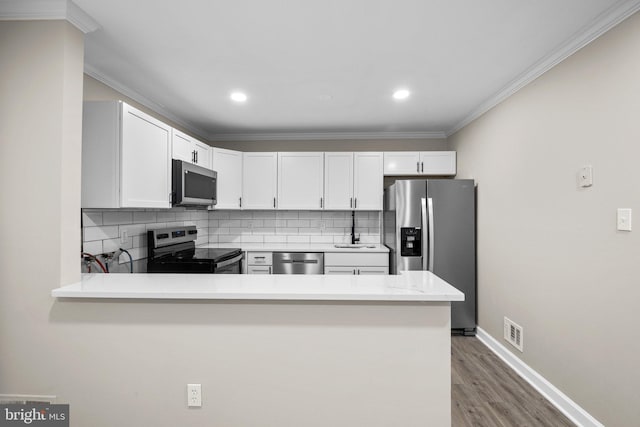 kitchen with white cabinetry, kitchen peninsula, and stainless steel appliances