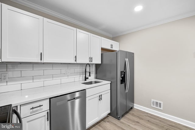 kitchen featuring stainless steel appliances, white cabinetry, sink, and light wood-type flooring