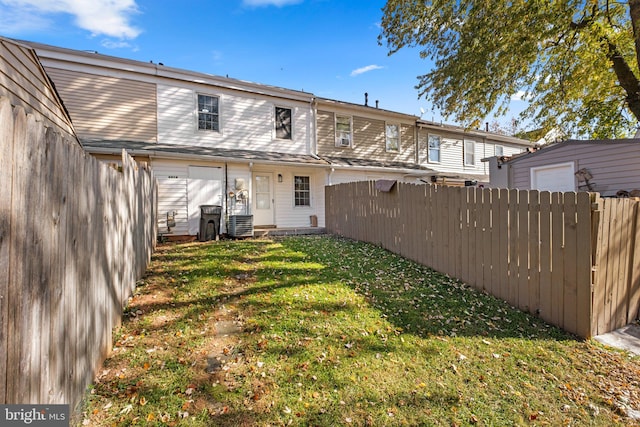 back of property featuring central AC unit and a yard