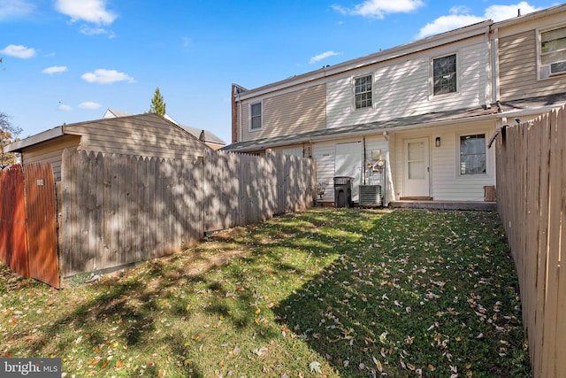 back of house featuring central air condition unit and a yard