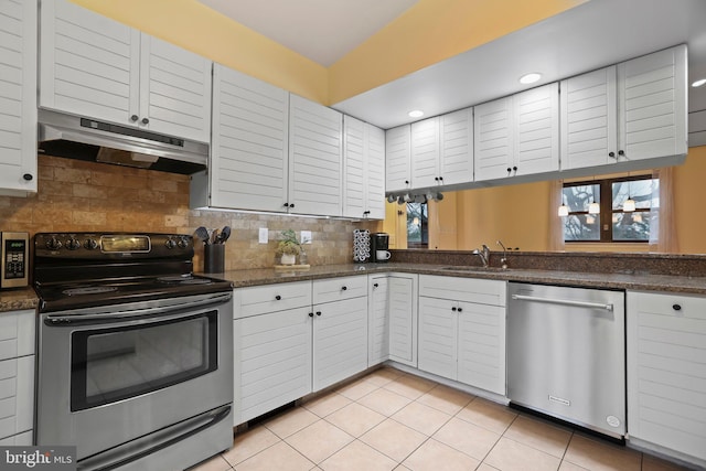 kitchen with appliances with stainless steel finishes, white cabinets, light tile patterned flooring, and decorative backsplash