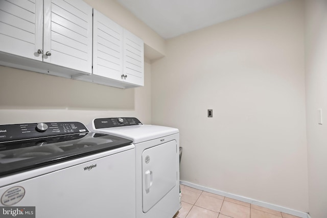 washroom featuring cabinets, light tile patterned flooring, and independent washer and dryer