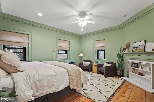 bedroom with ceiling fan, hardwood / wood-style flooring, and crown molding