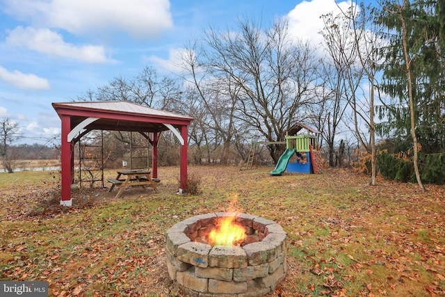 view of yard with a gazebo, a playground, and a fire pit