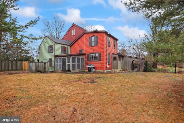 back of house with a lawn and a sunroom