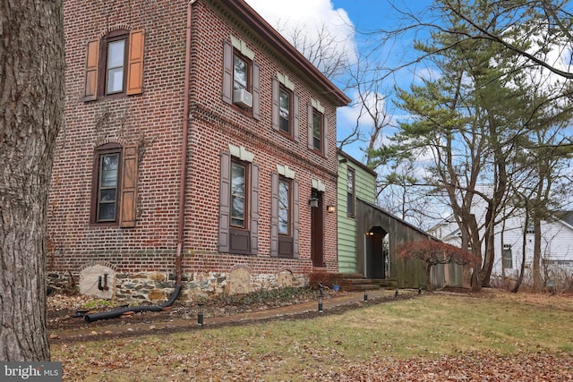 view of side of home with cooling unit and a yard