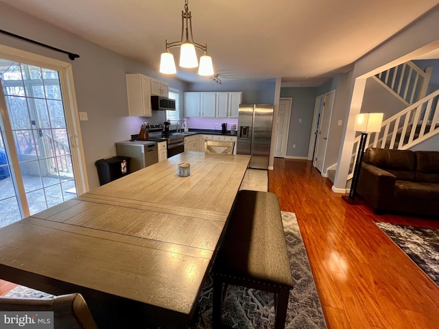 dining area featuring sink, an inviting chandelier, and wood-type flooring