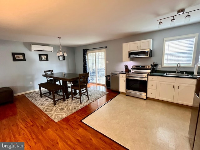 kitchen with a wealth of natural light, appliances with stainless steel finishes, sink, and light hardwood / wood-style floors