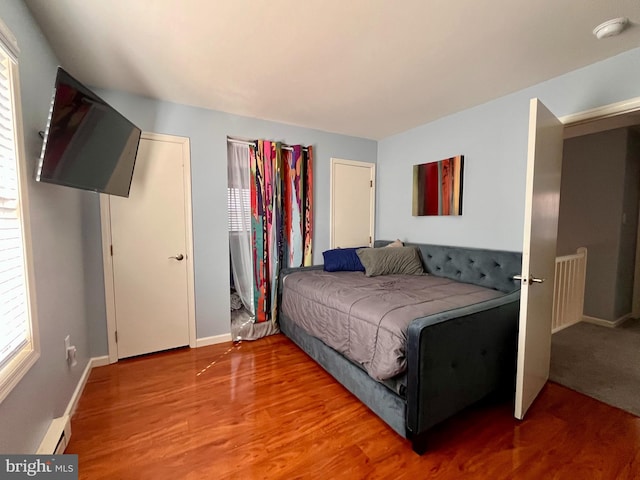 bedroom featuring hardwood / wood-style floors and baseboard heating