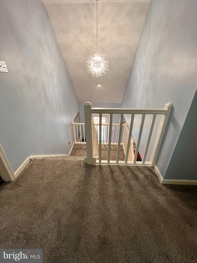 staircase featuring carpet flooring, an inviting chandelier, and high vaulted ceiling