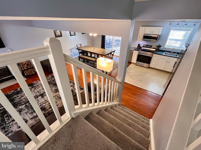 staircase with sink and hardwood / wood-style floors