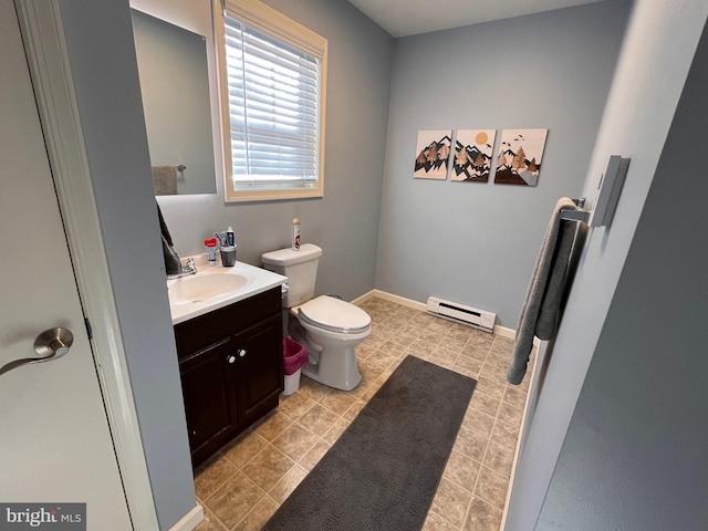 bathroom featuring a baseboard heating unit, tile patterned flooring, vanity, and toilet