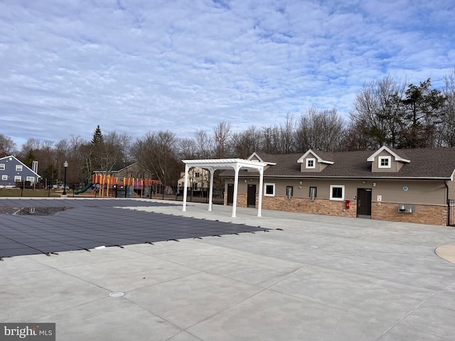 view of pool with a playground and a pergola