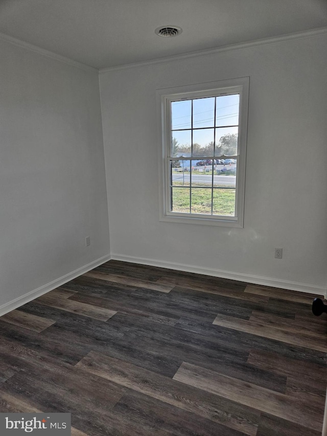 empty room featuring dark hardwood / wood-style floors and crown molding