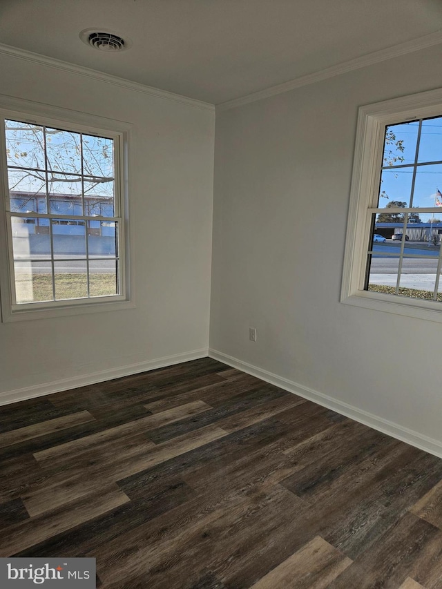 spare room with crown molding, a healthy amount of sunlight, and dark hardwood / wood-style floors