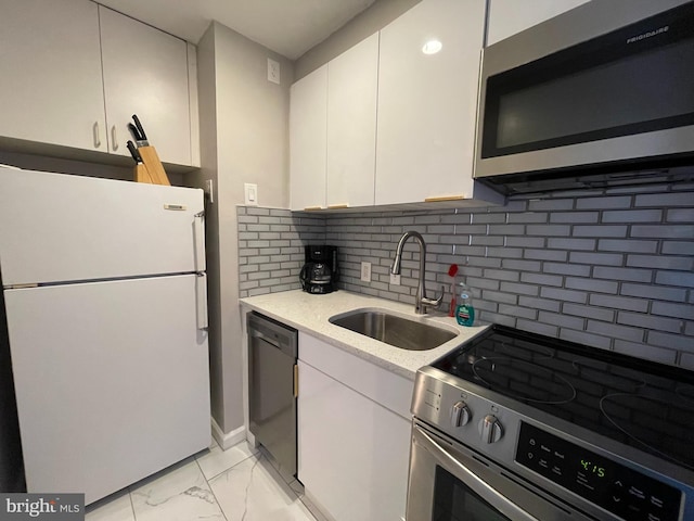 kitchen with tasteful backsplash, white cabinets, sink, and stainless steel appliances