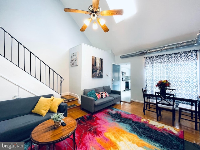 living room featuring hardwood / wood-style floors, ceiling fan, and high vaulted ceiling