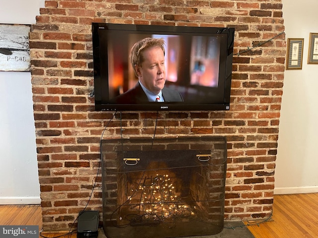 room details with a brick fireplace and hardwood / wood-style flooring