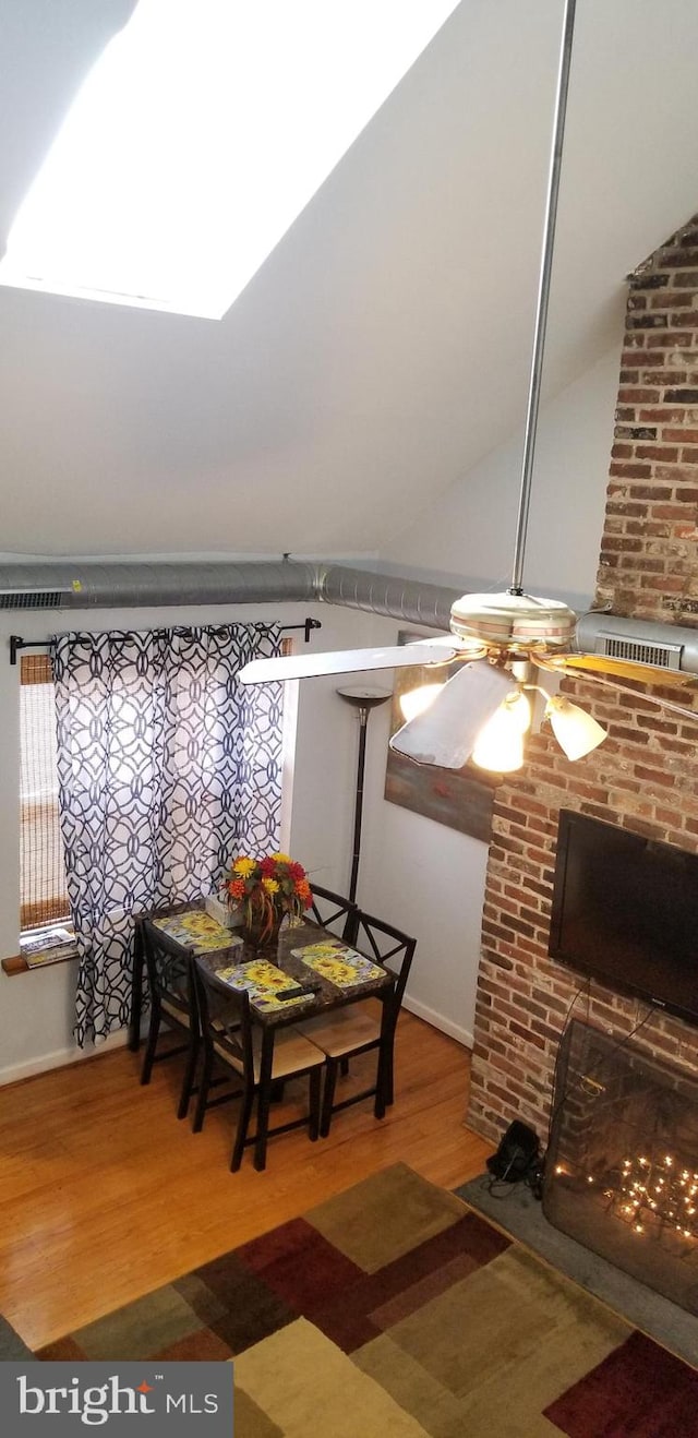 dining room with wood-type flooring, ceiling fan, and vaulted ceiling