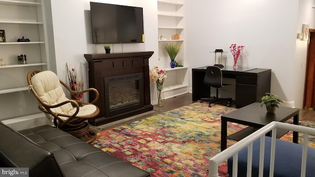 living room featuring built in features and dark hardwood / wood-style floors