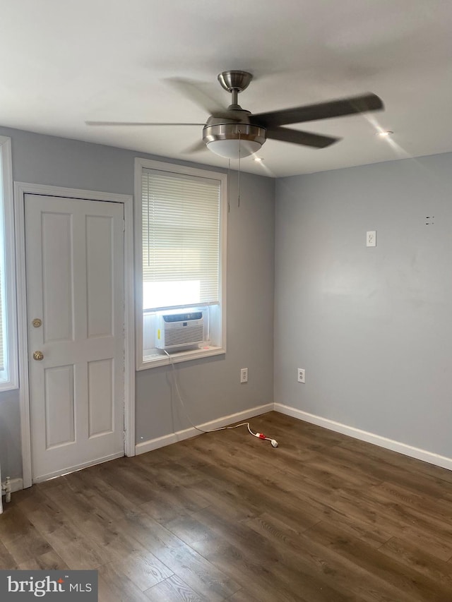 spare room featuring dark wood-type flooring, ceiling fan, and cooling unit