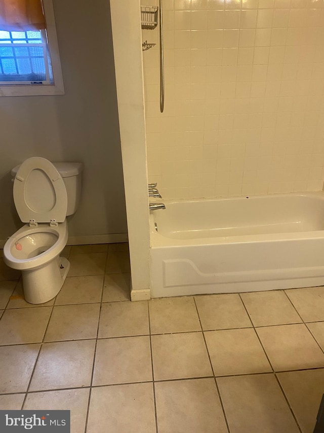 bathroom featuring tile patterned flooring, shower / washtub combination, and toilet