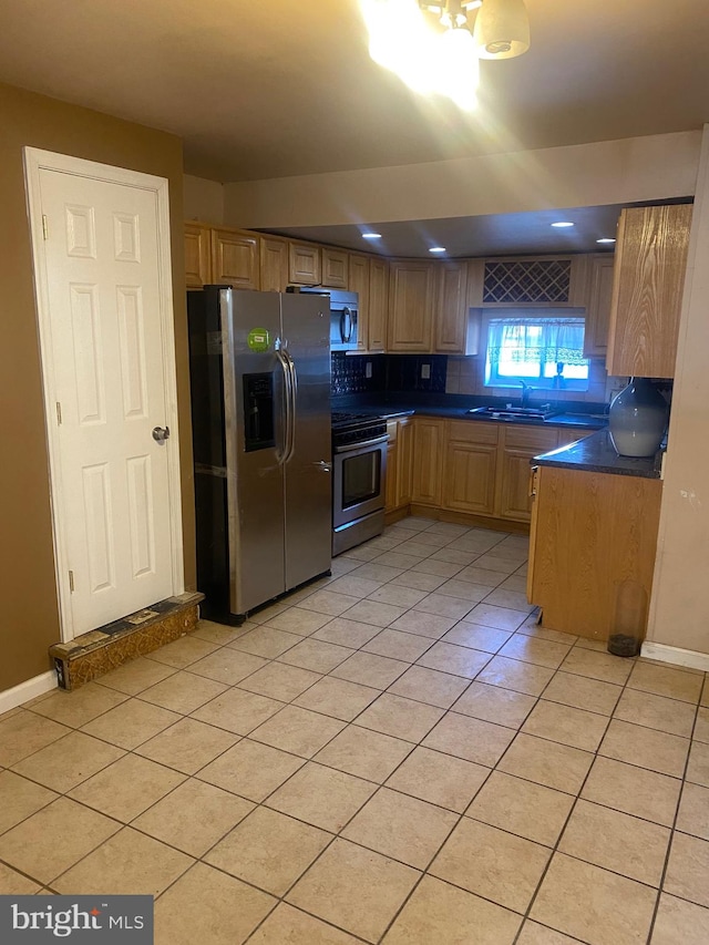 kitchen featuring stainless steel appliances, light tile patterned floors, sink, and tasteful backsplash