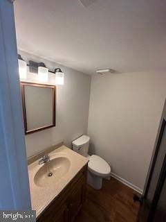 bathroom with toilet, vanity, and hardwood / wood-style flooring