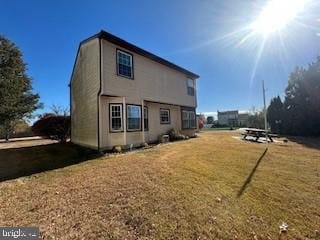 rear view of property featuring a lawn