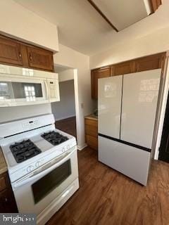 kitchen with white appliances and dark hardwood / wood-style flooring