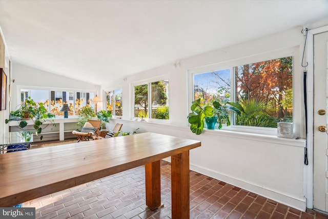 unfurnished sunroom featuring vaulted ceiling