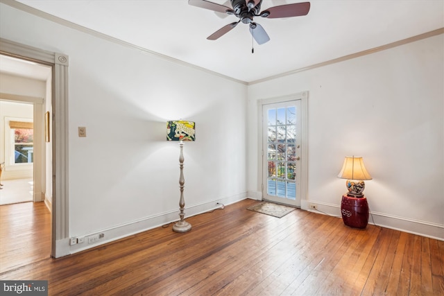 empty room featuring ornamental molding, hardwood / wood-style floors, and ceiling fan