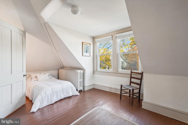 bedroom with lofted ceiling, wood-type flooring, and radiator